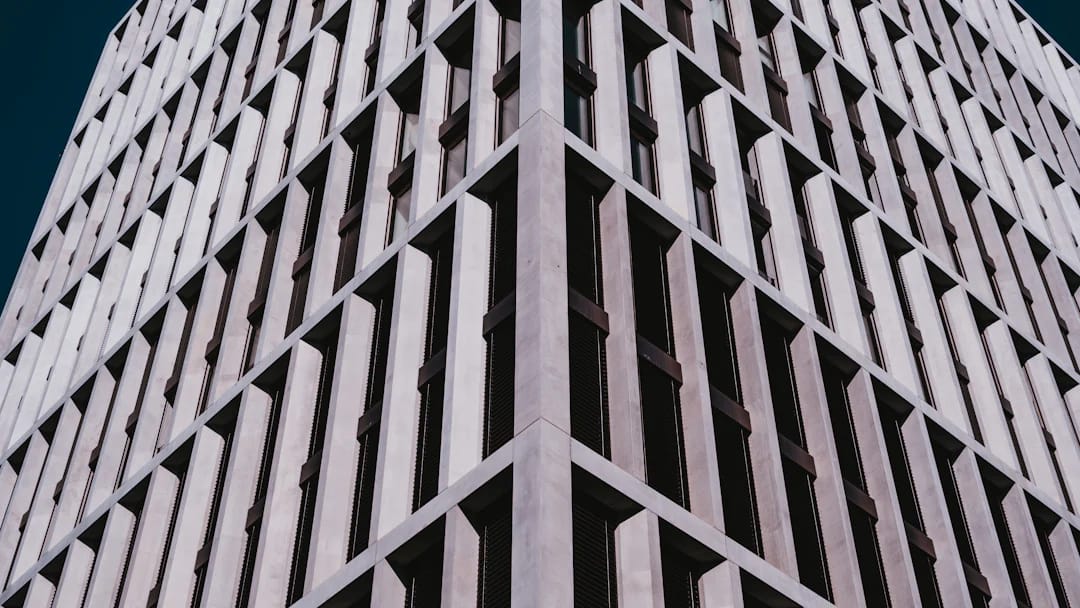 Façade géométrique d’un immeuble sous un ciel bleu, illustration des locaux commerciaux