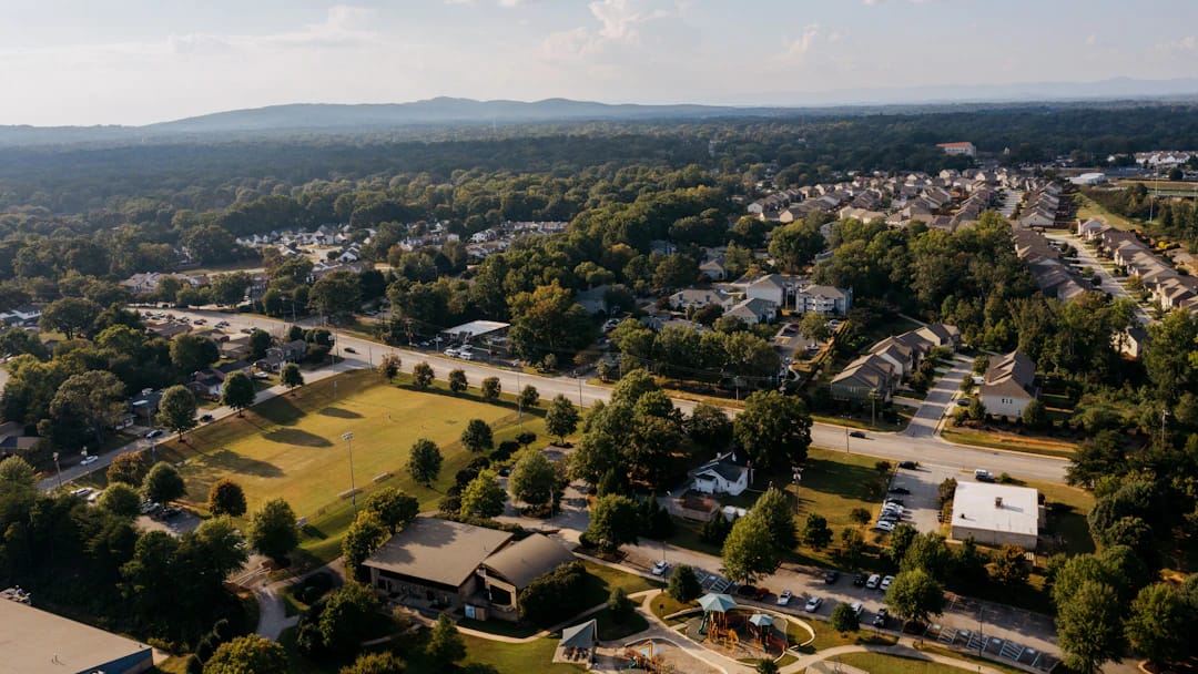 Vue aérienne d’un quartier résidentiel arboré — photo Alex Reynolds, Unsplash