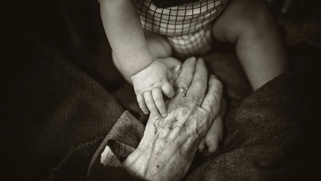 Mains d’une arrière-grand-mère et de son arrière-petit-fils — photo Rod Long, Unsplash