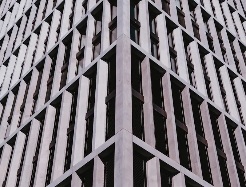 Façade géométrique d’un immeuble sous un ciel bleu, illustration des locaux commerciaux